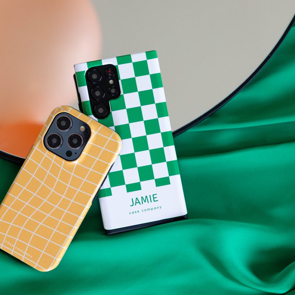 Kaks vastupidavat ümbrist: kollane ruuduline iPhone'ile ja roheline suureruuduline, millel on nimi Jamie